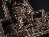 A miniature tabletop dungeon terrain set featuring dark, weathered stone walls and a grid-patterned floor with distressed brown and black textures. Two small character figurines stand on the tiles, one with a cape and one in armor.