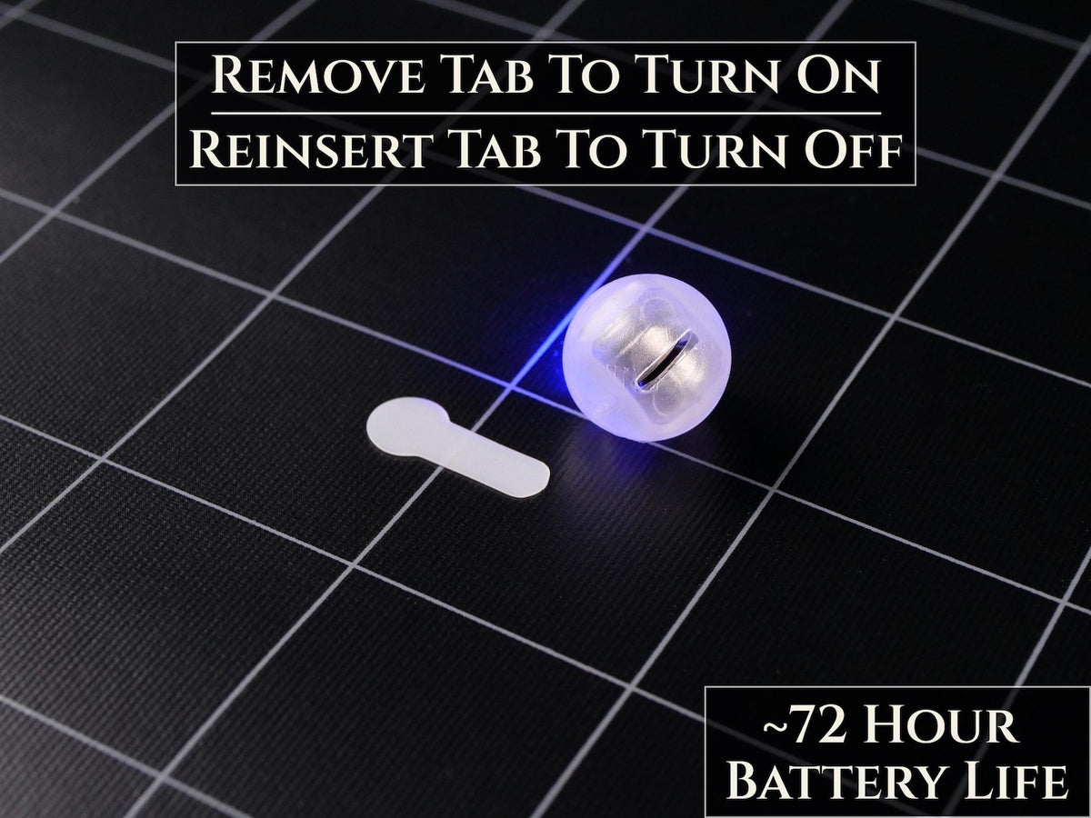 A small, spherical, translucent white LED light with a blue glow, accompanied by a white plastic pull tab. Text on the image reads: REMOVE TAB TO TURN ON, REINSERT TAB TO TURN OFF, and ~72 HOUR BATTERY LIFE.