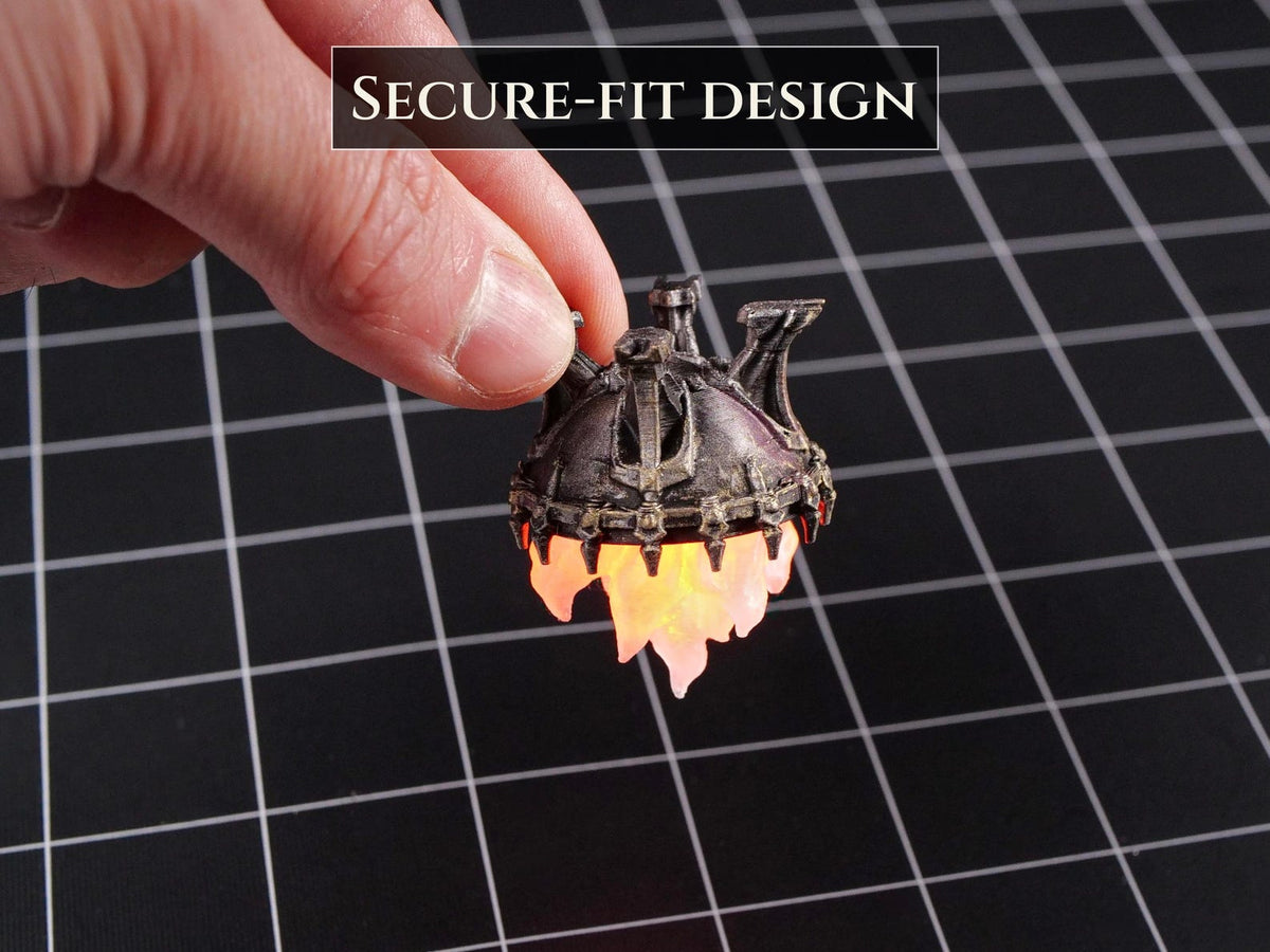 A small, metallic-colored, dome-shaped object with a dark, weathered finish and a glowing, translucent orange flame-like base. The object features a textured, architectural top and includes the text SECURE-FIT DESIGN.