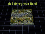 A square game tile featuring a textured, stone-like path surrounded by green, mossy terrain with raised root details. The text 4x4 Overgrown Road is printed in light green above the tile, which sits on a black grid surface.