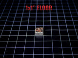 A small square tile measuring 1x1 inch with a textured, multi-colored surface featuring shades of brown, black, and metallic tones. The tile is positioned on a black grid background with the red text 1x1" FLOOR printed above it.