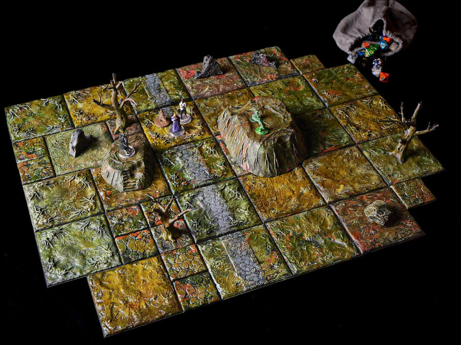 A tabletop role-playing game board composed of square, textured tiles painted in shades of green, brown, and yellow. The board features raised terrain elements, including rocky hills and bare trees, with several small character miniatures.