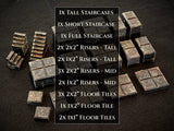 A collection of dark gray stone-textured gaming terrain pieces including staircases, risers, and floor tiles. The text lists: 1x Tall Staircases, 1x Short Staircase, 1x Full Staircase, 2x 2x2" Risers - Tall, 2x 1x2" Risers - Tall, 3x 2x2" Risers - Mid, 2x 1x2" Risers - Mid, 3x 2x2" Floor Tiles, 1x 1x2" Floor Tile, 2x 1x1" Floor Tiles.