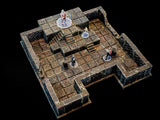 A miniature tabletop dungeon terrain set featuring a dark stone-textured floor with a raised platform, stone stairs, and surrounding walls. Four small painted character figurines stand on clear circular bases within the grid.