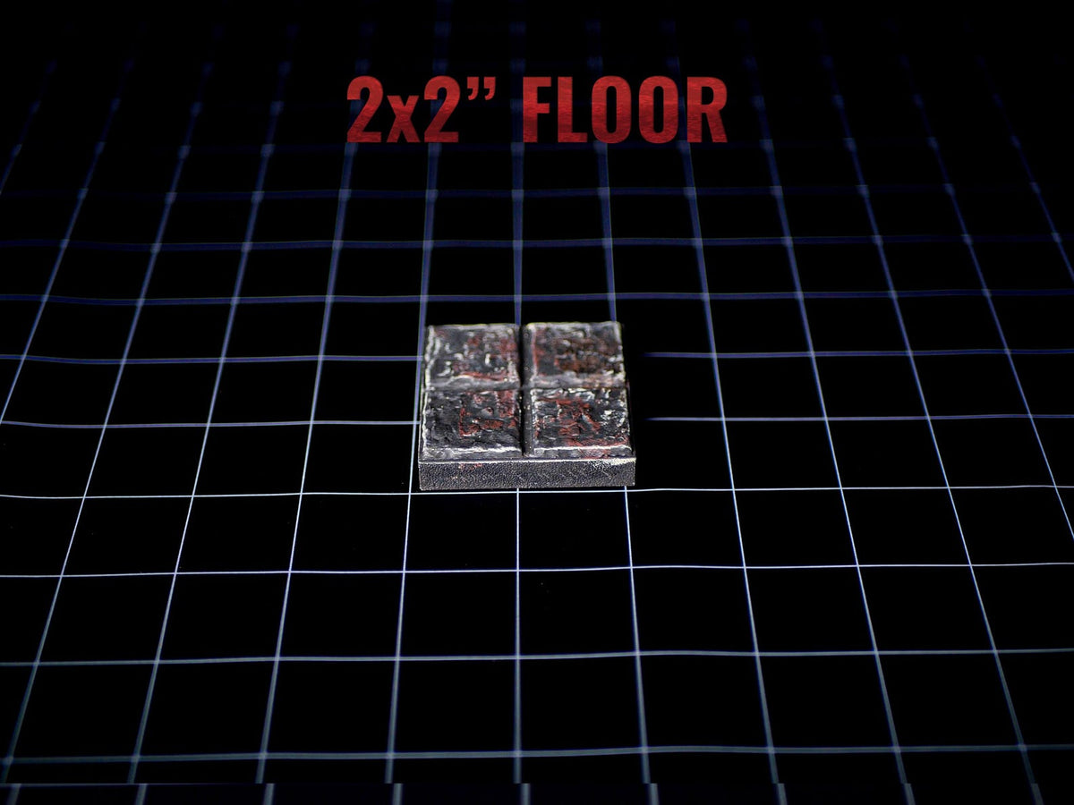 A square 2x2 inch floor tile piece with a dark, weathered stone texture featuring deep grey and reddish-brown tones. The surface is divided into four smaller square sections by a cross-shaped groove, creating a realistic stone floor appearance.